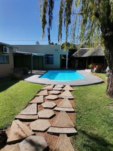 un patio trasero con piscina y un camino de rocas en Nonesi Lodge 2, en Queenstown