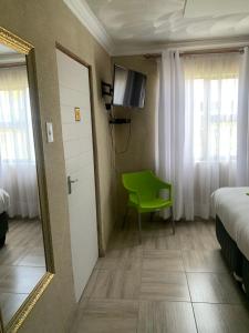Zimmer mit einem Spiegel und einem grünen Stuhl in der Unterkunft Nonesi Lodge 2 in Queenstown