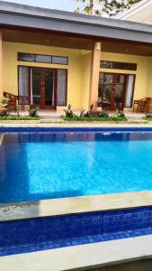 D'Natha Villa Ubud في أوبود: مسبح ازرق كبير امام المنزل