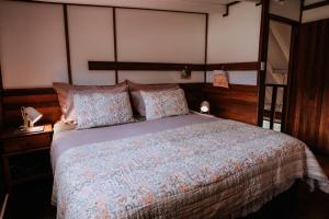 a bedroom with a bed with a wooden headboard and pillows at Cottage 3 - The Row in Forest Grove