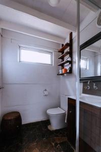 a bathroom with a toilet and a sink and a window at Cottage 3 - The Row in Forest Grove