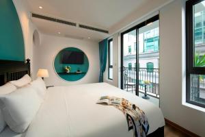 a bedroom with a white bed and a window at Hotel De Rond in Hanoi