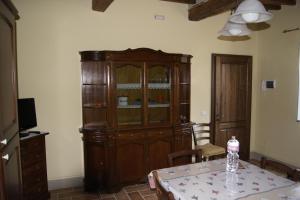 une salle à manger avec une grande armoire en bois et une table dans l'établissement La Casa del Falegname, à Umbertide
