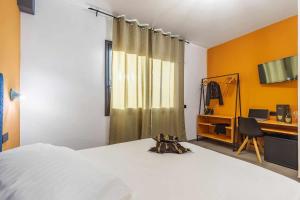 um quarto com uma cama, uma secretária e uma cadeira em BB OgliastRoom em Tortolì