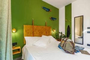 um quarto verde com uma cama com uma mochila em BB OgliastRoom em Tortolì