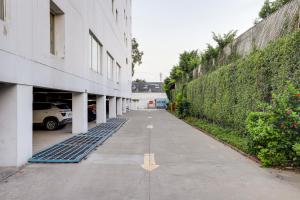 an empty sidewalk next to a building with a hedge at Lemon Tree Hotel Chandigarh in Chandīgarh