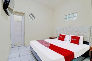 Sumedang的住宿－OYO Life 91480 Putridapisa Syariah，卧室配有带红色枕头的大型白色床