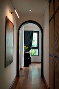 a hallway with an archway with a window and a mirror at Hotel De Rond in Hanoi