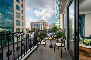 a balcony with a table and chairs and a view of a city at Hotel De Rond in Hanoi