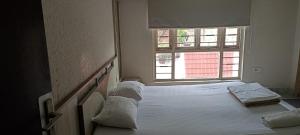 Ballygunj Guest House في كولْكاتا: غرفة نوم بسرير كبير ونافذة