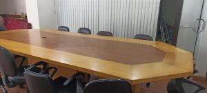 Ballygunj Guest House في كولْكاتا: طاولة خشبية كبيرة في غرفة مع كراسي