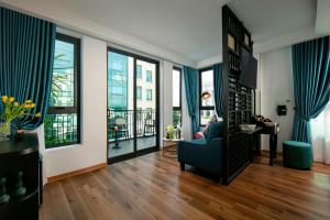 - un salon avec des rideaux bleus et une chaise bleue dans l'établissement Hotel De Rond, à Hanoï