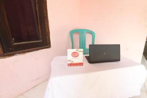 stół z laptopem i niebieskim krzesłem w obiekcie OYO 93246 Kanditha Homestay w mieście Montongbuwoh