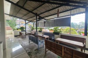 a restaurant with benches and tables and windows at Capital O 93250 Hotel Tirta Kencana 2 Baturaden in Banyumas