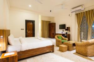 The Kaziranga Address في كازيرانغا: غرفة نوم مع سرير وغرفة معيشة