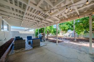 an outdoor patio with awning and chairs and a table at Elegant Retreat w/ Game room in Heart of OC in Midway City