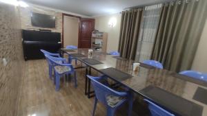 una sala de conferencias con una mesa larga y sillas azules en INJIR Hostel en Dushanbe