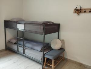 MaarkedalにあるVakantiehuis 't Leideveldの二段ベッド2台と椅子が備わる客室です。