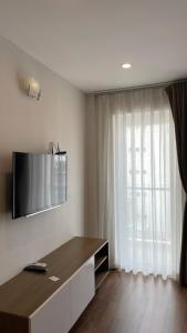 a living room with a flat screen tv on the wall at The Jade Apartment in Ho Chi Minh City