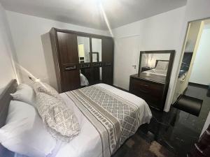 1 dormitorio con cama y espejo grande en A louer Appartement 2 pièces à Rosny-sous- Bois, en Rosny-sous-Bois