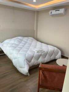 Cama en habitación con manta blanca en el suelo en Hotel Nagarjun Palace en Katmandú