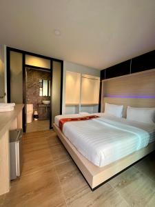 een slaapkamer met een groot bed en een badkamer bij Phi Phi Rimlay Resort in Phi Phi Don