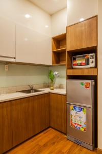 a kitchen with a stainless steel refrigerator and a sink at The Jade Apartment in Ho Chi Minh City