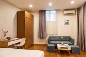 a hotel room with a bed and a couch at The Jade Apartment in Ho Chi Minh City