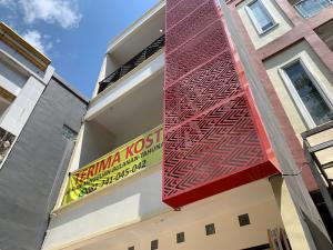 Un edificio con un cartel al costado. en Hotel O Mely Homestay, en Kendari