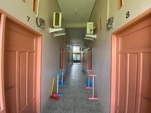 um corredor vazio com bancos azuis e cor-de-rosa em OYO 93309 Mely Homestay em Kendari