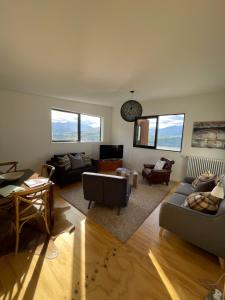 Sala de estar con 2 sofás y mesa en Lake view apartment La Hay 66, en Queenstown