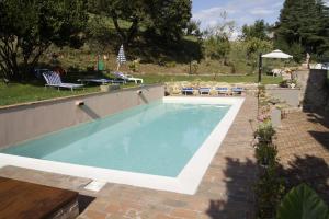 a swimming pool in a yard with a patio at La Casa del Falegname in Umbertide