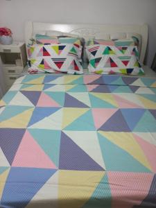 uma cama com uma colcha colorida e almofadas em Azure Urban Resort and Residences Bahamas Tower em Manila