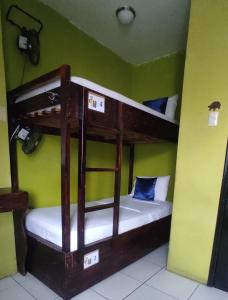 two bunk beds in a room with green walls at Dreamkapture Hostel close to the airport and bus terminal in Guayaquil