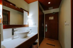 un bagno con lavandino e specchio di Hotel Devaragam by K P Namboodiri's a Guruvayoor