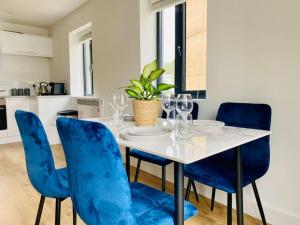 a dining room with a table with blue chairs at Apartment 12 Contractors & Professionals 