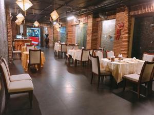 una sala da pranzo con tavoli e sedie in un ristorante di Little Gold Hue boutique hotel a Hue