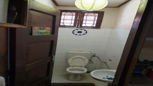 a bathroom with a toilet and a sink and a clock at Nina Homes in Dar es Salaam