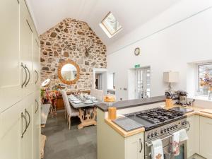 a kitchen with a table and a stone wall at Staggart House in Banff
