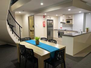 a kitchen and dining room with a table and chairs at City Ville Apartments and Motel in Rockhampton