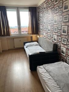 een slaapkamer met 2 bedden en een muur met foto's bij Center Piac Aparman in Debrecen