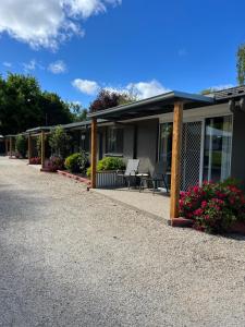 ein Haus mit einer Terrasse und Blumen davor in der Unterkunft Willow Dene Holiday Apartments in Bright