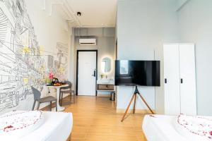 a living room with a tv on a wall at Emerald Hotel Residence in Phnom Penh