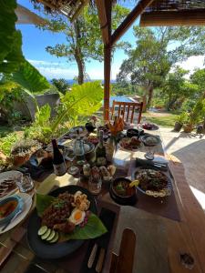 a table with plates of food and bottles of wine at Nakabalo Guesthouse & Restaurant in Siquijor
