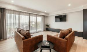 a living room with two chairs and a table at Met Apartments in Port Lincoln