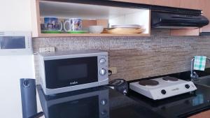 a kitchen with a microwave and a television on a counter at Luxury Budget Condo in Central Cebu in Cebu City