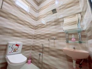a bathroom with a toilet and a sink at Roomstay HELLOKITTY HOUSE in Kuala Terengganu