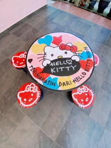 a table with a hello kitty cake on the floor at Roomstay HELLOKITTY HOUSE in Kuala Terengganu
