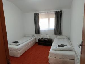 een kamer met twee bedden en een raam bij Старият Хан-Б24 in Bansko