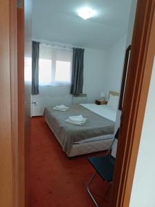 een slaapkamer met een bed, een stoel en een raam bij Старият Хан-Б24 in Bansko